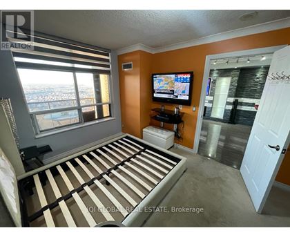 A bedroom with a large bed and a flat screen TV.