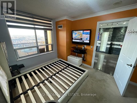 A bedroom with a large bed and a flat screen TV.