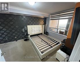 A bedroom with a large bed and a patterned wallpaper.