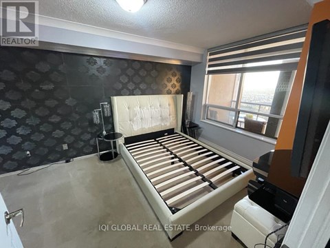 A bedroom with a large bed and a patterned wallpaper.
