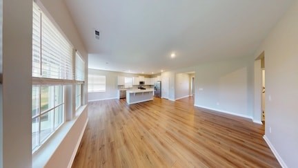A spacious room with wooden floors and white walls.