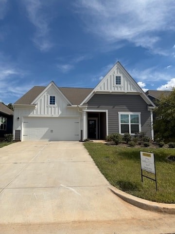 A house with a grey roof and white walls has a sign in front of it.