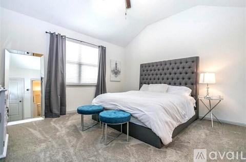 A bedroom with a large bed and a chandelier.
