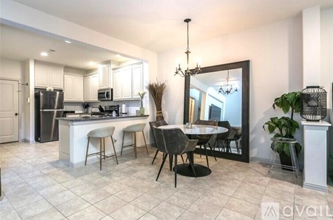 A kitchen with a dining table and chairs.