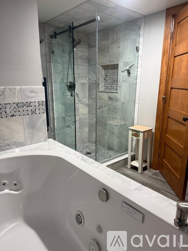 A bathroom with a black vanity and a white bathtub.
