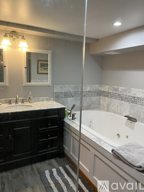 A bathroom with a black vanity and a white bathtub.