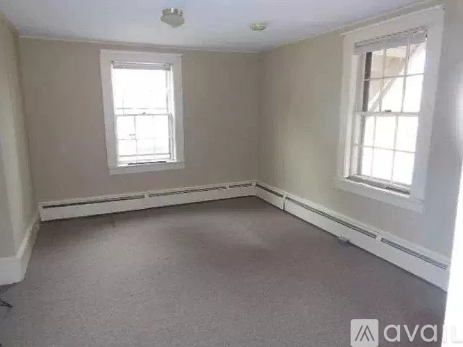 A room with two windows and a carpeted floor.