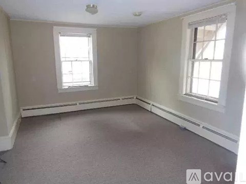 A room with two windows and a carpeted floor.