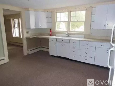A kitchen with white cabinets and a window.