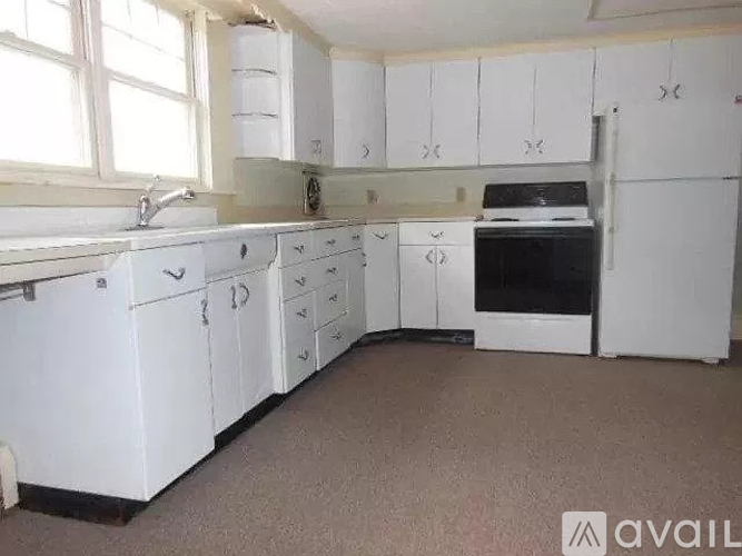 A kitchen with white cabinets and appliances is available for rent.