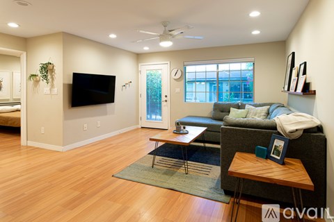 A living room with a grey couch and a wooden table.