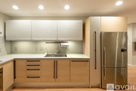 A modern kitchen with a stainless steel refrigerator and wooden cabinets.