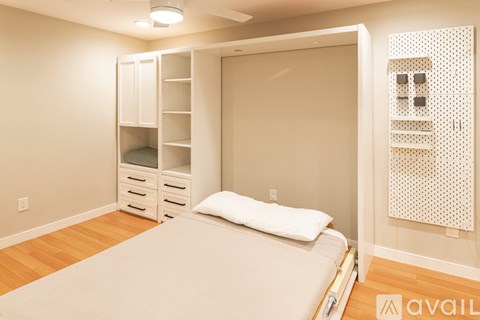 A bedroom with a bed, nightstand, and a closet with shelves.