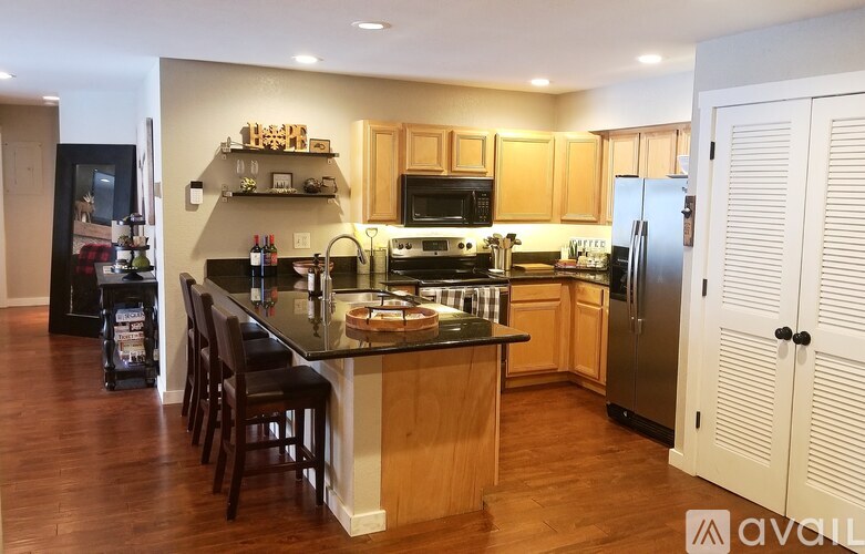 A kitchen with wooden cabinets and a black countertop.