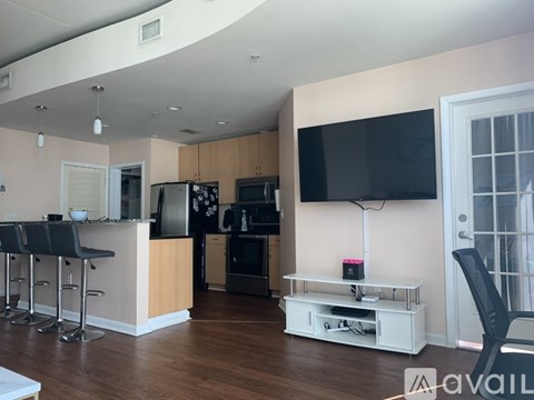 A kitchen with a bar area and a television.