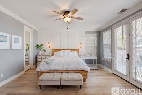 A bedroom with a large bed and a ceiling fan.