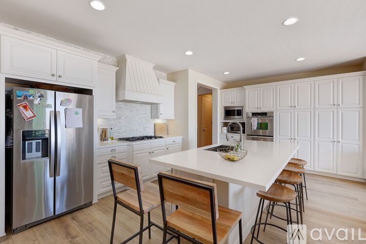 A kitchen with a white table and chairs.