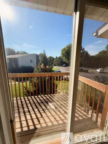 A balcony with a view of a house and trees.