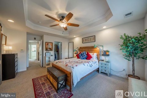 A bedroom with a large bed and a ceiling fan.