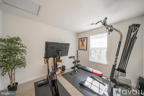 A home gym with a treadmill, weights, and a yoga mat.
