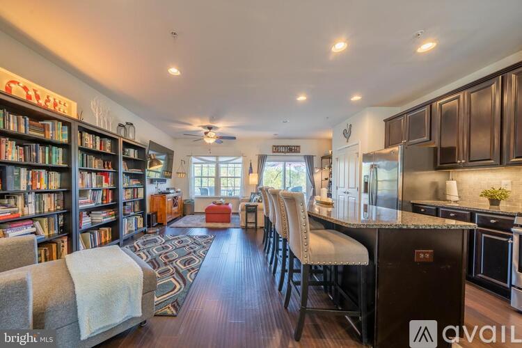 A well-lit kitchen and living room with a bookshelf filled with books.