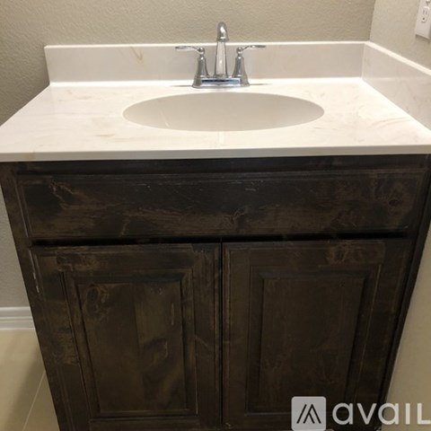 A white sink is on top of a wooden cabinet.