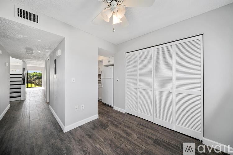 A spacious room with a sliding door and a chandelier hanging from the ceiling.