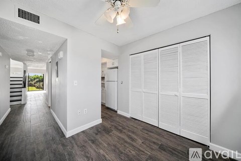 A spacious room with a sliding door and a chandelier hanging from the ceiling.