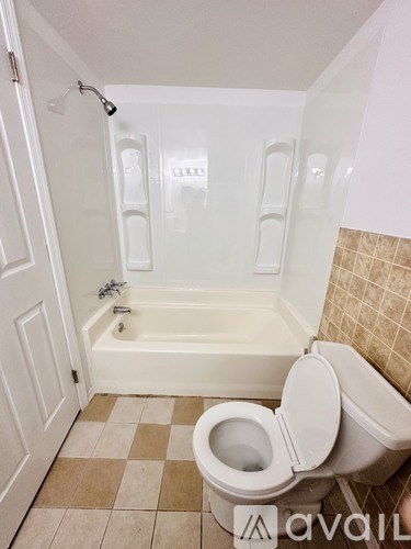 A bathroom with a toilet, tub, and shower.