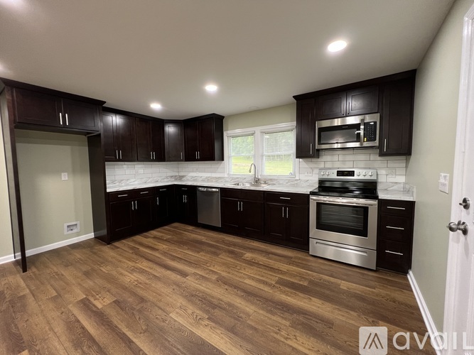 A kitchen with dark wood cabinets and stainless steel appliances.