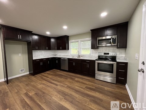 A kitchen with dark wood cabinets and stainless steel appliances.