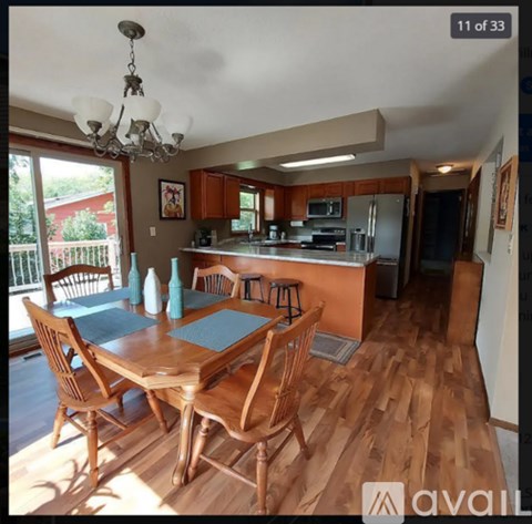 A kitchen with a table and chairs in front of it.