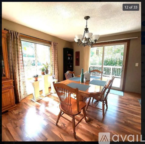 A dining room with a wooden table and chairs.