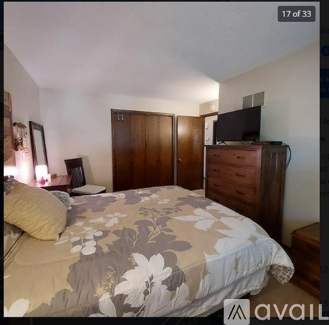 A bedroom with a bed, dresser, and wardrobe.