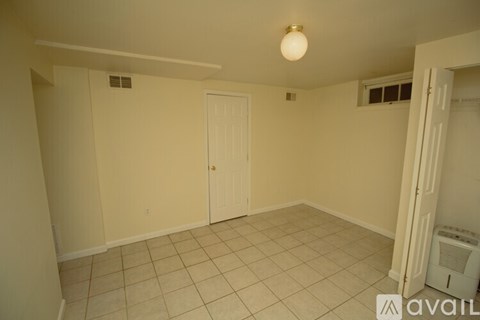 A room with a door and a fan on the wall.