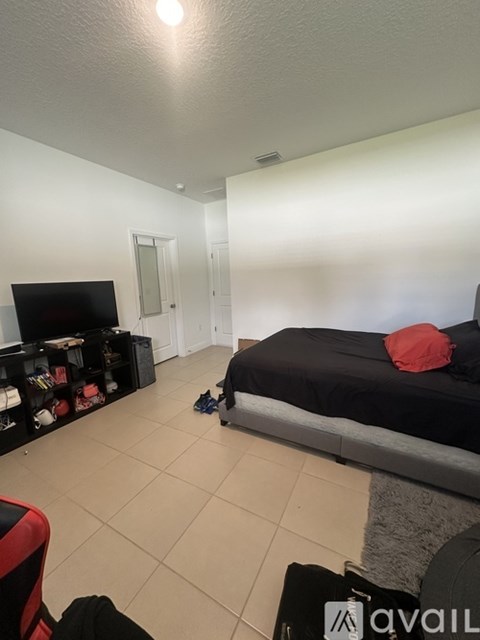 A bedroom with a bed, a television, and a bookshelf.