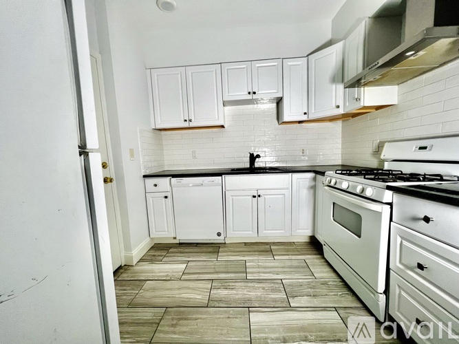 A kitchen with white cabinets and a black stove top oven.