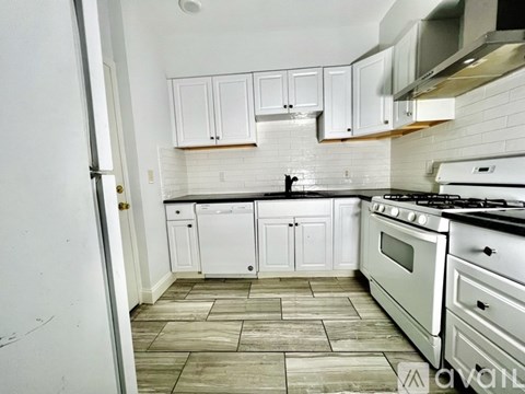 A kitchen with white cabinets and a black stove top oven.