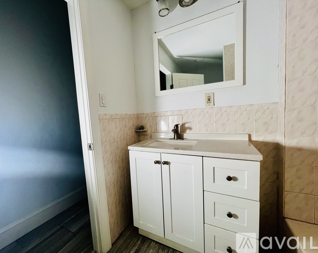 A white bathroom vanity with a mirror above it.