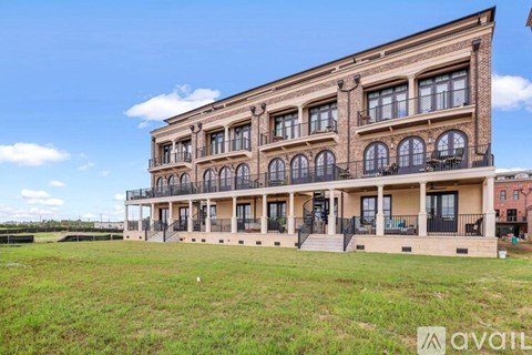 A large, multi-story building with a balcony on the second floor is available for rent.