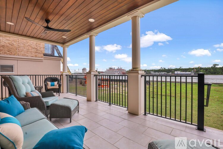 A balcony with a wooden ceiling and a black railing.