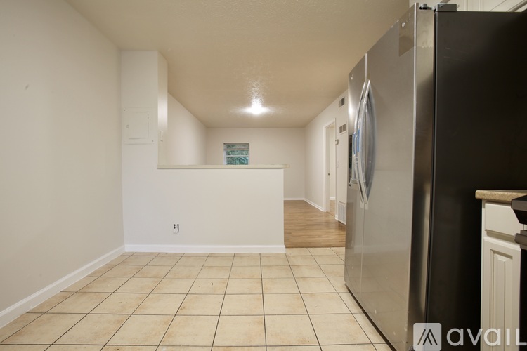 A kitchen with a refrigerator on the right side.