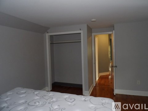 A bedroom with a bed and a door leading to another room.