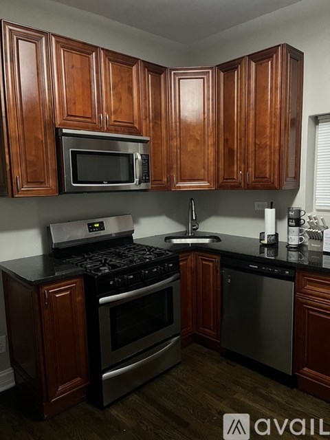 A kitchen with wooden cabinets and black countertops.