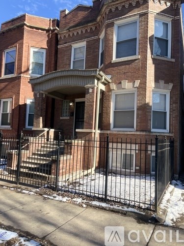 A brick building with a black fence in front.