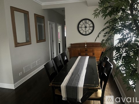 A dining room with a wooden table and chairs.