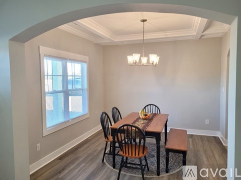 A dining room with a wooden table and chairs.
