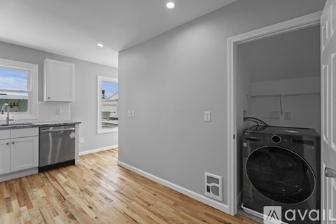 A kitchen with a dishwasher and a washing machine in the laundry room.