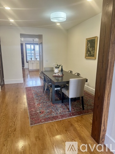 A dining room with a wooden table and chairs.