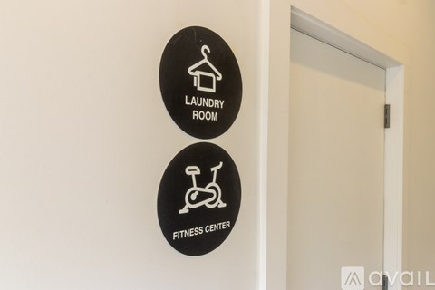 Two signs on a wall, one says laundry room and the other says fitness center.
